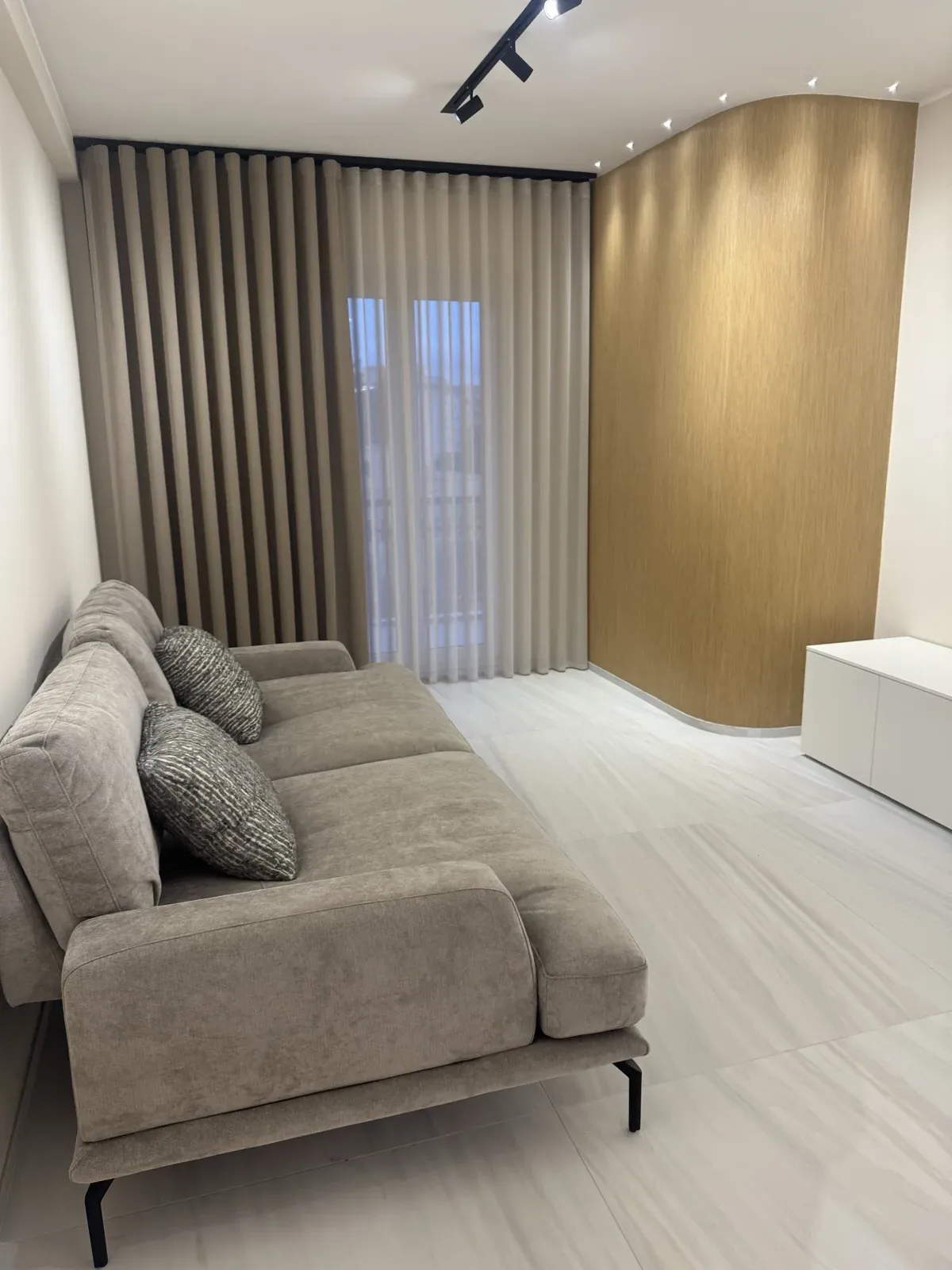 Salotto con tende su misura e parete in legno